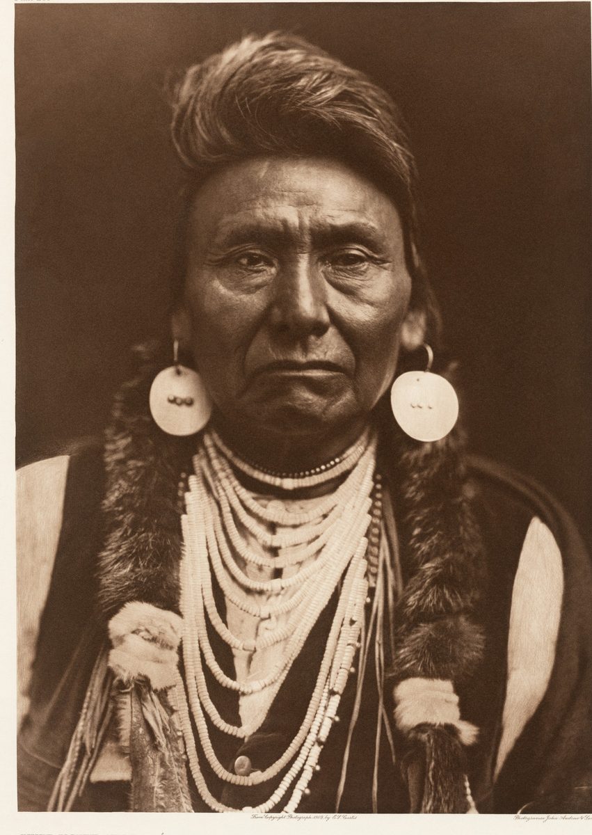 Sepia photogravure portrait of Chief Joseph of the Nez Perce by Edward S. Curtis, 1903, head and shoulders with shell earrings and swept-up hair